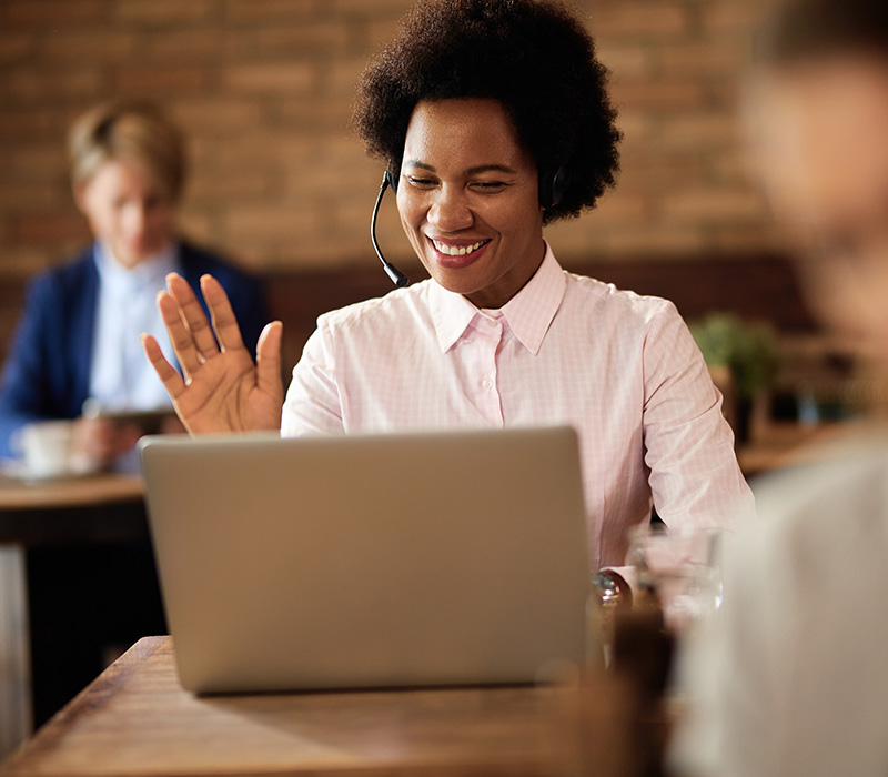 Business woman working happily on her laptop using wireless internet